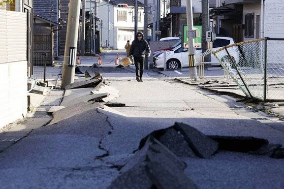 지난 2일 일본 이시카와현 하쿠이시에서 한 주민이 지진으로 파손된 거리를 걷고 있다. AP=연합뉴스