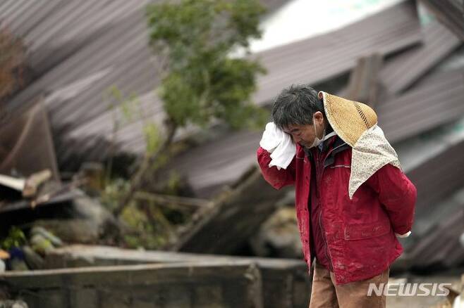 [스즈=AP/뉴시스] 3일 일본 이시카와현 스즈의 한 주민이 지진으로 무너진 집 잔해 속에서 가족의 시신이 발견되자 흐느끼고 있다. 지난 1일 이시카와현 노토반도에서 발생한 지진으로 지금까지 사망자 숫자는 최소 62명으로 늘어났다. 2024.01.03.