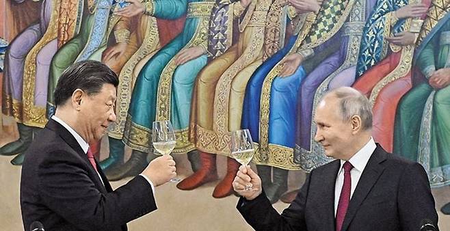 푸틴은 시진핑과 중국어로 “간베이” - 21일(현지 시각) 시진핑(왼쪽) 중국 국가주석과 블라디미르 푸틴 러시아 대통령이 모스크바 크렘린궁에서 열린 국빈 만찬에서 건배하고 있다. 푸틴은 중국어로 “간베이(乾杯)”를 외쳤다. /로이터 연합뉴스