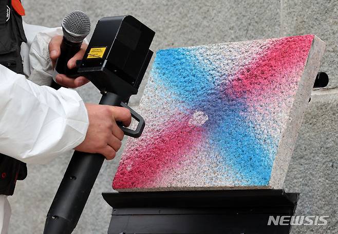 [서울=뉴시스] 조성우 기자 = 4일 오전 서울 종로구 경복궁 영추문에서 이태종 국립문화재연구원 학예연구사가 레이저 장비를 활용해 낙서 제거 작업을 시연하고 있다. 2024.01.04. xconfind@newsis.com