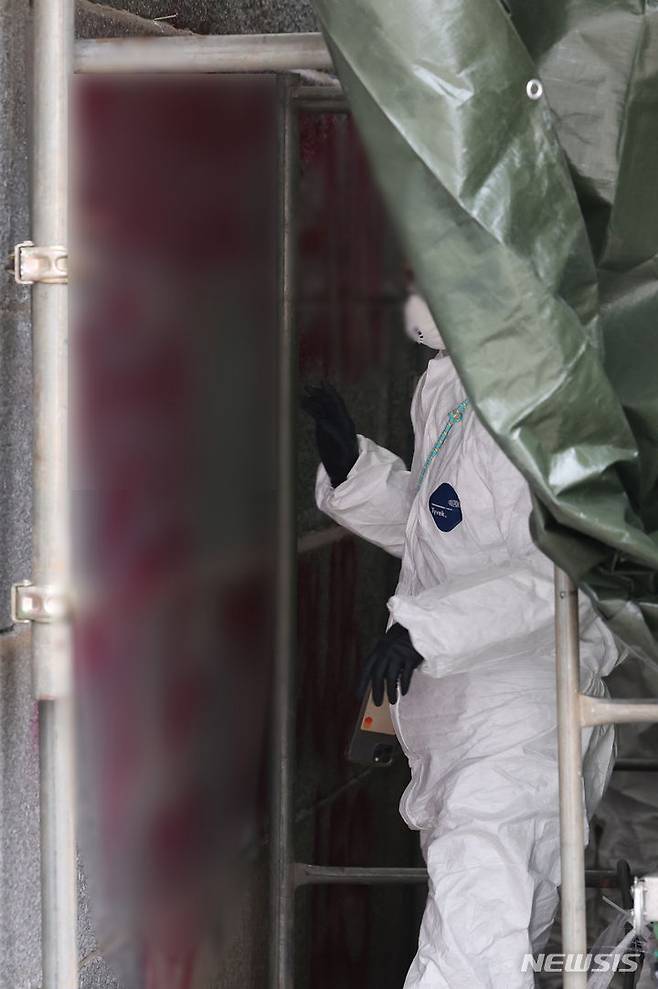 [서울=뉴시스] 김진아 기자 = 경복궁 담벼락을 스프레이로 훼손한 사건이 일어난지 나흘째인 19일 서울 종로구 경복궁 영추문 인근에서 문화재청 관계자들이 복구 작업을 하고 있다. 2023.12.19. bluesoda@newsis.com