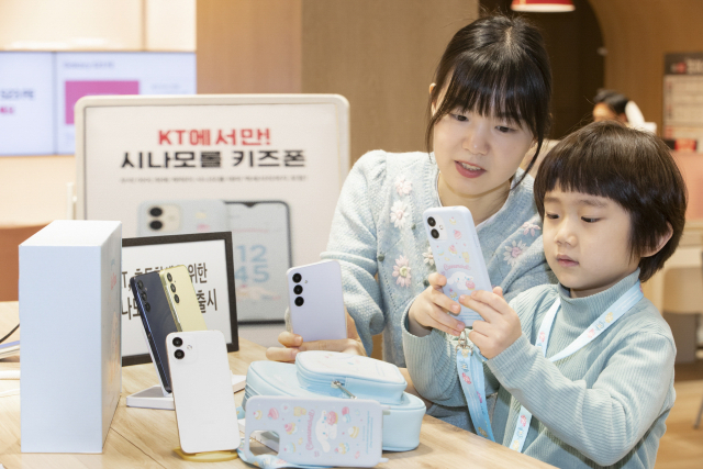 KT가 어린이 전용 스마트폰 ‘시나모롤 키즈폰’를 5일부터 KT 공식 온라인몰에서 판매를 앞두고 있는 가운데 한 어린이가 어머니 옆에서 스마트폰을 만지고 있다. 사진 제공=KT