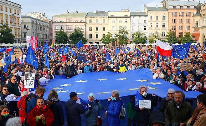 “우리는 제2의 영국이 되기 싫어요” - 10일(현지 시각) 폴란드 전(前) 수도인 크라쿠프시(市) 중앙 광장에 모인 시민들이 대형 유럽연합(EU) 기(旗)를 흔들며 ‘EU 탈퇴 반대’ 시위를 벌이고 있다. 폴란드에서는 최근 헌법재판소가 “EU 조약보다 폴란드 헌법이 우위에 있다”고 결정하면서 현 집권 세력이 EU 탈퇴를 추진할 가능성이 제기됐다. /AP 연합뉴스