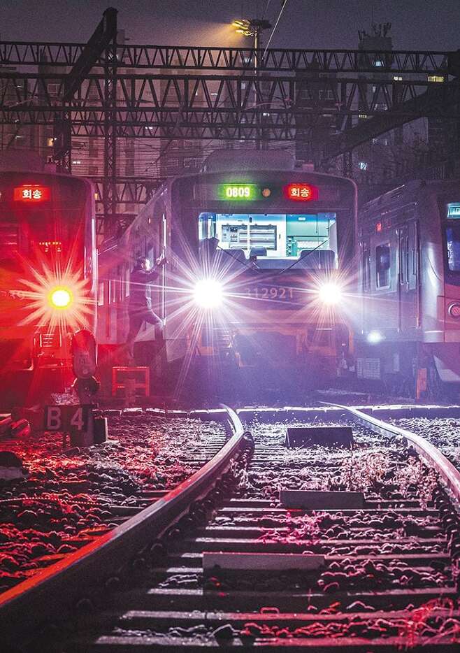 지난 1일 새벽 구로차량기지, 전조등을 밝힌 새해 첫 1호선 열차에 기관사가 탑승하고 있다. 열차가 얼어붙은 철로를 녹이며 구로역에 닿으면, 이마에 붉은 글씨로 표시된 '회송'은 종점의 이름으로 바뀔 것이었다. /이신영 영상미디어 기자