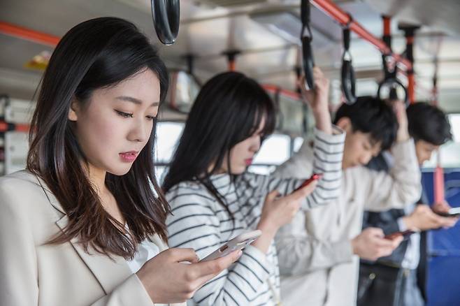 스마트폰에서 눈을 떼지 못하는 사람들. 저자는 ‘잠깐이라도 스마트폰이 없는 상태가 되는 것이 꺼려지는지’ 등 15개 항목으로 
구성된 ‘스마트폰 강박 테스트’ 표를 담았다. 체크한 항목이 8개가 넘으면 전문가 상담이 필요하다. 게티이미지코리아