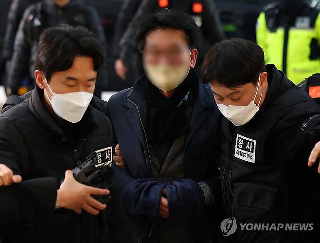 부산경찰청으로 압송되는 이재명 흉기 습격 피의자 (부산=연합뉴스) 손형주 기자 = 더불어민주당 이재명 대표를 흉기로 습격한 피의자 김모씨(가운데)가 지난 2일 부산 연제구 부산경찰청으로 압송되는 모습. 2024.1.2 handbrother@yna.co.kr
