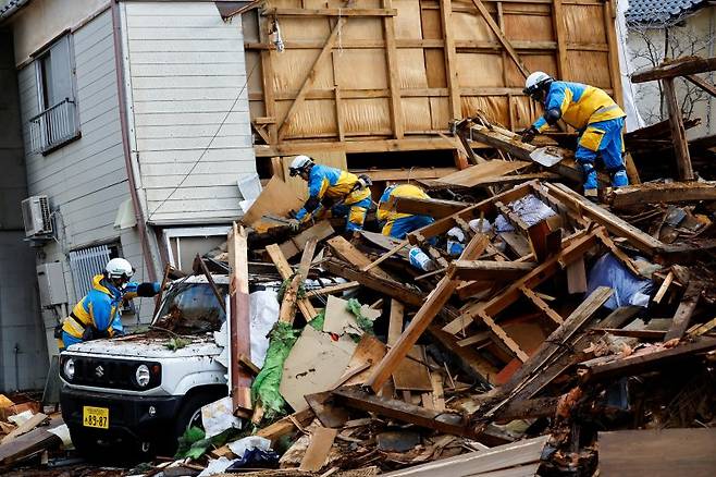 지난 4일 일본 이시카와현 와지마에서 경찰관들이 지진으로 무너진 집 잔해를 수습하고 있다. 뉴스1