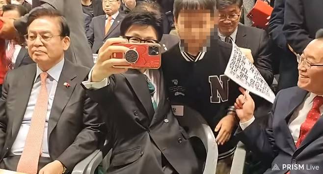 지난 4일 충북 청주 장애인스포츠센터에서 열린 국민의힘 충북도당 신년 인사회에서 한동훈 비상대책위원위원장과 한 어린이가 기념 사진을 촬영하고 있다. 한 위원장이 '이재명처럼 되고 싶지 않습니다'라는 문구가 적힌 손팻말을 왼손으로 집어 카메라 프레임 밖으로 내보내는 모습이다. /유튜브 김사랑 시인