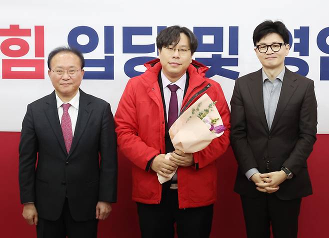 지난 8일 국회에서 열린 국민의힘 입당 및 영입 환영식에서 한동훈 비상대책위원장과 윤재옥 원내대표가 학교폭력 전문 변호사인 박상수 변호사에게 당 점퍼를 입혀주고 기념촬영을 하고 있다. 연합뉴스.