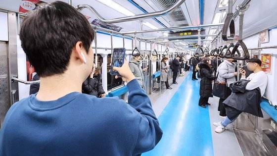 10일 오전 의자 없이 운행하는 서울 지하철 4호 열차에서 한 승객이 열차 내부를 촬영하고 있다. 전날 서울교통공사는 지하철 혼잡도를 완화하기 위해 4호선 열차 1개 칸의 객실 의자를 제거하는 시범사업을 이날 출근길부터 시작한다고 밝혔다. 연합뉴스