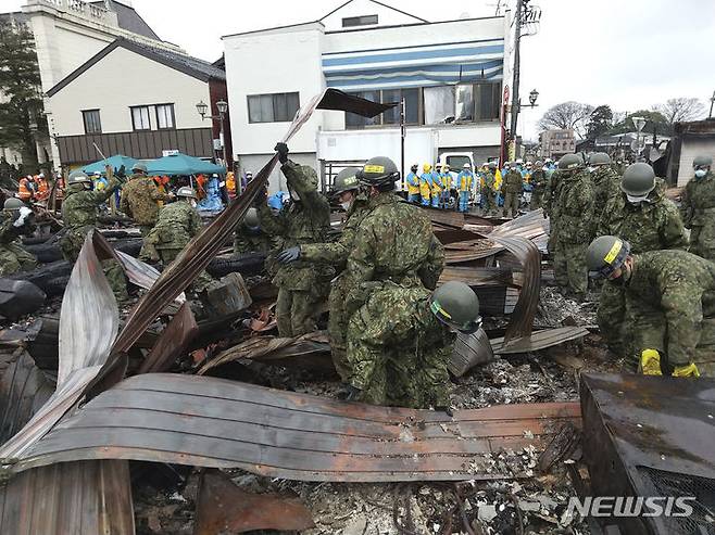 [이시카와=AP/뉴시스]일본 국토지리원은 지난 1일 발생한 규모 7.6 강진으로 노토(能登)반도 끝 중앙부가 남서쪽으로 최대 약 2m 이동했다는 분석 결과를 10일 발표했다. 사진은 일본 방위성이 제공. 10일 자위대 대원들이 지난 1일 이시카와현 와지마시에서 강진으로 인한 대규모 화재가 발생했던 아침시장에서 수색 작업을 벌이는 모습이 담겼다. 2024.01.10.