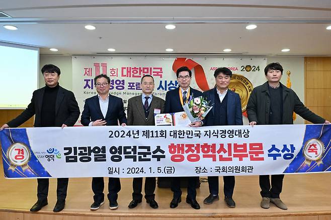 김광열(왼쪽서 네번째) 영덕군수가 이성모(왼쪽서 세 번째) 대회장와 영덕군 직원들의 축하를 받으며 대한민국 지식경영대상을 수상한 후 기념 촬영을 하고 있다. 영덕군 제공