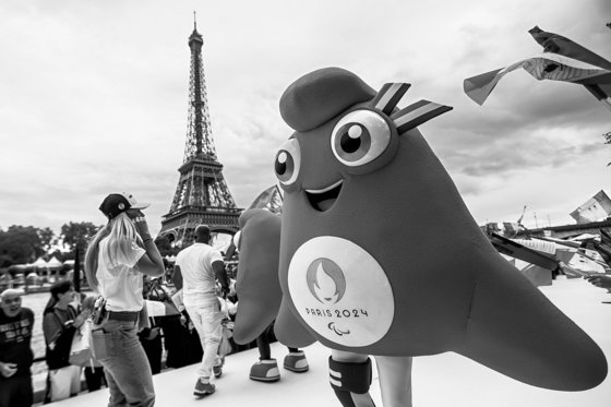 지난해 7월 25일(현지시간) 프랑스 파리 에펠탑 인근 센강 강둑에서 열린 퍼레이드에서 2024 파리 올림픽 공식 마스코트들과 선수들, 팬들이 함께 춤을 추고 있다. EPA=연합뉴스
