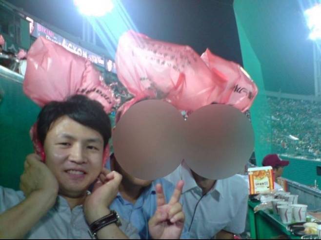 국민의힘이 12일 공개한 한동훈 비상대책위원장의 10여년 전 과거 사진. 부산 사직구장에서 머리에 비닐을 쓰고 응원전을 하고 있다. [사진제공=국민의힘]