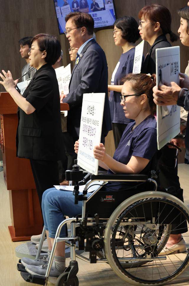 더불어민주당 우원식 의원과 반도체 노동자의 건강과 인권지킴이 반올림이 지난해 10월 국회에서 산업재해 선보장을 통한 국가책임제 실현 촉구 기자회견을 하고 있다. 휠체어를 탄 산재 피해자 한혜경씨. 연합뉴스