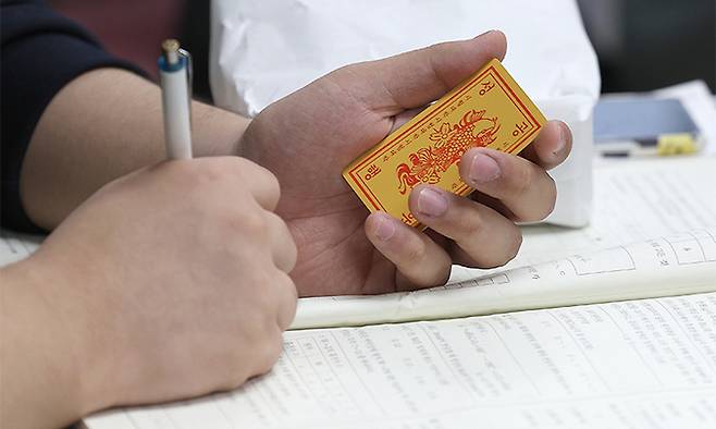 한 고3 수험생이 후배들이 나눠준 합격부적을 손에 쥐고 공부를 하고 있다. 연합뉴스