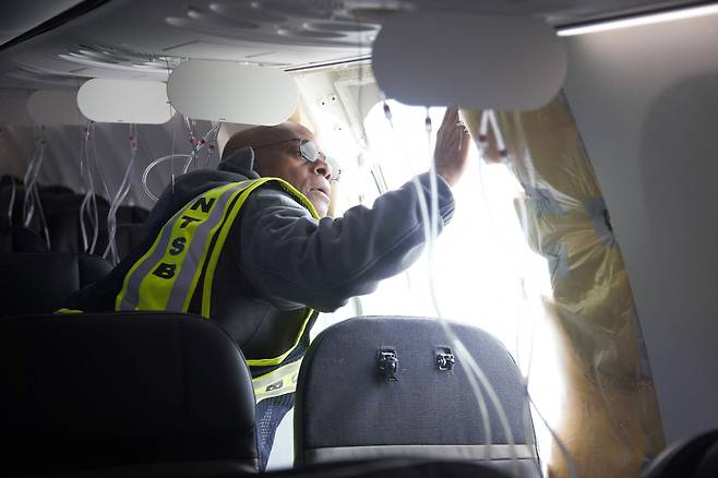 미국 국가교통안전위원회(NTSB) 조사관이 오리건주 포틀랜드에서 비행 중 뜯겨나간 알래스카 항공 1282편 보잉 737 맥스 9 항공기의 비상구 덮개(도어 플러그)를 살펴보고 있다. /연합뉴스