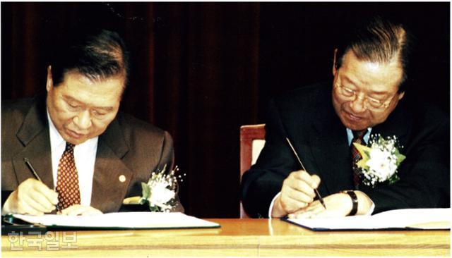 김대중(왼쪽) 국민회의 총재와 김종필 자민련 총재가 1997년 11월 3일 국회 의원회관 대회의실에서 양당 후보단일화 합의문에 서명하고 있다. 한국일보 자료사진