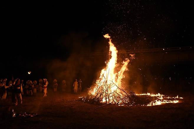 옥천 교평리 주민 등이 무형문화재로 지정된 ‘옥천 교평리 강줄 당기기’의 하나로 줄다리를 한 줄을 태우며 마을의 안녕과 풍년을 기원하고 있다.옥천군 제공