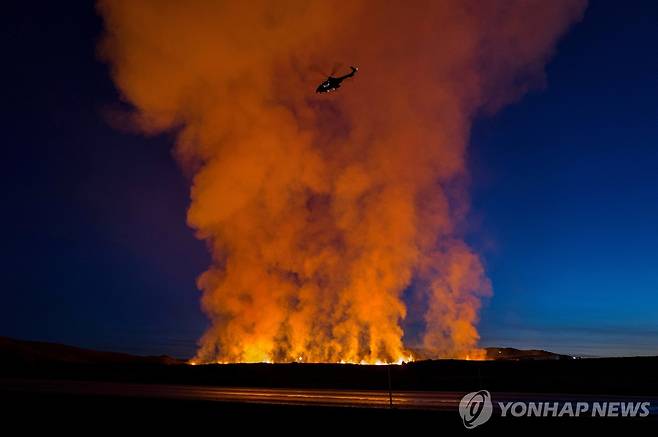 아이슬란드 그린다비크  화산 분화 14일(현지시간) 아이슬란드 그린다비크에서 화산 분화로 연기가 치솟는 가운데 헬리콥터가 주변을 지나고 있다. [아이슬란드 해안경비대 제공·로이터 연합뉴스 자료사진. 재판매 및 DB 금지] 2024.1.15 photo@yna.co.kr