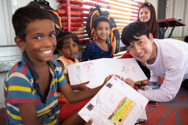 유엔난민기구 친선대사인 정우성이 2019년 방글라데시 쿠투팔롱 난민 캠프의 배움터를 찾아 로힝야 난민 어린이들을 만나고 있다. 유엔난민기구 제공