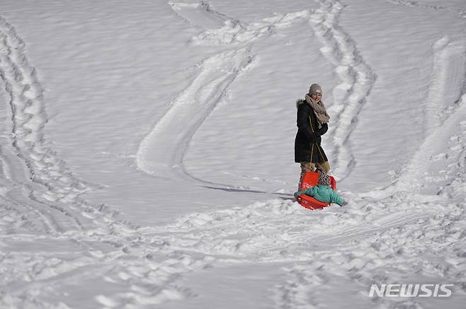 [테네시=AP/뉴시스] 과학자들이 전 세계에서 비정상적으로 따뜻한 날씨가 이어지는 동안 미국에 북극 한파가 덮친 이유로 지구 온난화를 꼽았다고 AP통신이 16일(현지시간) 전했다. 사진은 미국 테네시주 내슈빌에서 썰매를 타고 있는 모녀의 모습. 2024.01.17.