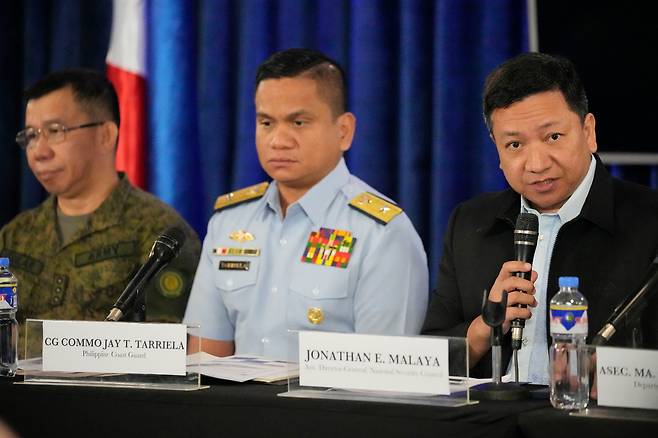 지난달 필리핀 국가안보위원회 대변인 조너선 말라야(오른쪽)가 마닐라에서 자국 해안경비대 대변인 제이 타리엘라(가운데), 육군 대변인 메델 아길라르 대령과 나란히 앉아 기자회견하고 있다. 이들은 중국 해안경비정이 남중국해에서 필리핀 해군 보급선을 향해 물대포를 발사했다고 밝히며 이에 항의했다./AP연합뉴스