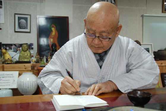 성파 스님이 수첩에 메모를 하고 있다. 뒤쪽으로 직접 그린 불화와 도자기 작품 등이 보인다. 성파 스님은 깨달음의 이치를 예술 작품으로도 펼쳐낸다. 백성호 기자