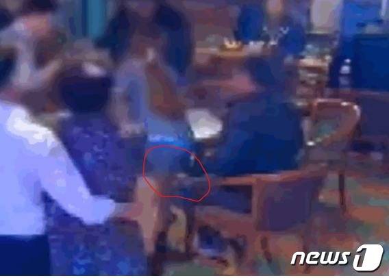 지난해 12월 전북 익산의 한 술집에서 한 남성이 여 직원 치마속에 손(붉은 원)을 집어넣고 있다. (jtbc  갈무리) ⓒ 뉴스1
