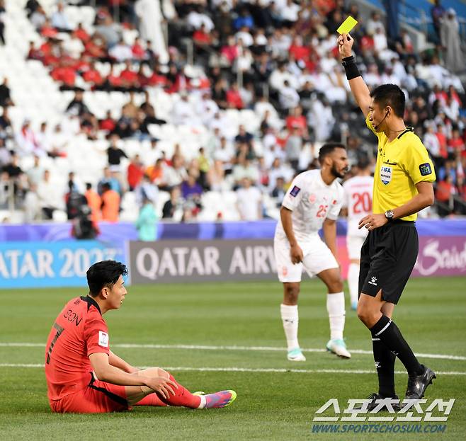 15일(현지시간) 카타르 도하 자심 빈 하마드 스타디움에서 열린 2023 아시아축구연맹(AFC) 카타르 아시안컵 대한민국과 바레인의 경기. 주심이 손흥민에게 옐로카드를 주고 있다. 도하(카타르)=박재만 기자 pjm@sportschosun.com/2023.01.15/