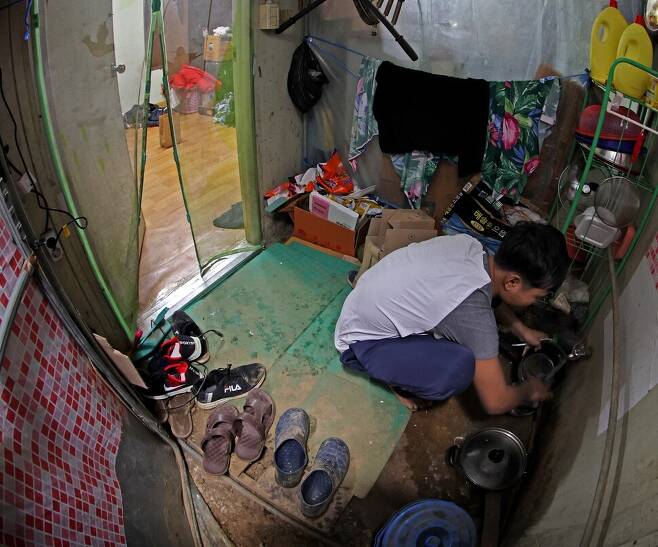 지난 16일 저녁 경기도 포천의 한 시설채소 농장에서 캄보디아 출신 이주노동자가 비닐하우스 기숙사에서 찬물로 그릇을 씻고 있다. 이정용 선임기자 lee312@hani.co.kr