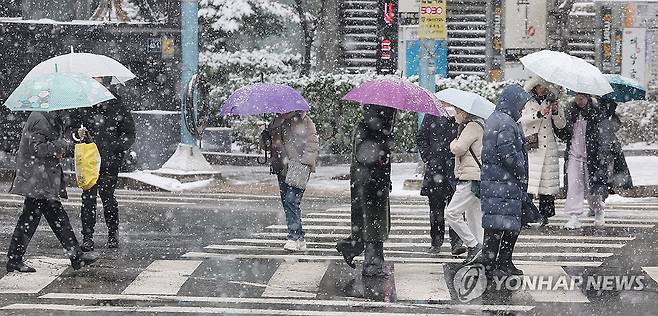 눈 펑펑 내리는 거리 (서울=연합뉴스) 박동주 기자 = 눈이 내린 17일 오후 우산을 쓴 시민들이 서울 종로구 한 거리를 지나고 있다. 2024.1.17 pdj6635@yna.co.kr