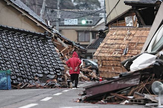 지진 발생 3주, 돌아오지 못하는 일상 - 지난 15일 일본 이시카와현 노토반도 와지마시에 주택 잔해들이 깔려 있다. 지난 1일 규모 7.6 강진으로 232명이 숨지고 건물 3만1659채가 무너진 가운데, 지진 당일 한 고교 대피소의 음료 자판기 세 대를 파손, 음료수를 나눠준 일부 피난민의 조치가 도마에 올랐다. “비상 상황에 따른 불가피한 조치”라는 평가보다 “허가 없는 파손이라 처벌 대상”이라는 의견이 많다. /AFP 연합뉴스
