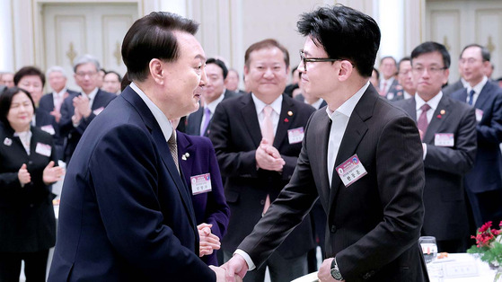 President Yoon Suk Yeol, left, shakes hands with People Power Party (PPP) interim leader Han Dong-hoon at a New Year’s event held at the Blue House state guest house in central Seoul on Jan. 3. [JOINT PRESS CORPS]