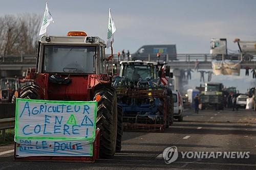 한 트랙터 앞에 "농부들이 화났다"는 현수막이 걸려 있다. [AFP 연합뉴스 자료사진 재판매 및 DB 금지]