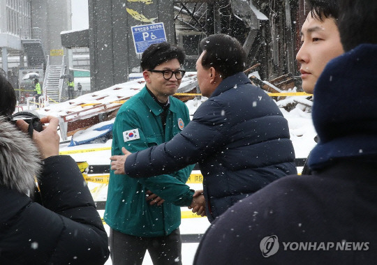 윤석열 대통령이 23일 충남 서천군 서천읍 서천특화시장 화재 현장에서 국민의힘 한동훈 비상대책위원장과 만나 인사하고 있다. 연합뉴스