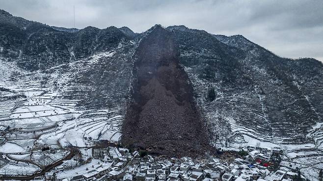 22일 촬영된 중국 남서부 윈난성 자오퉁의 량수이 마을 산사태 현장. 산 아래 마을이 쏟아진 흙에 성냥갑처럼 밀려나고 있다. EPA 연합뉴스
