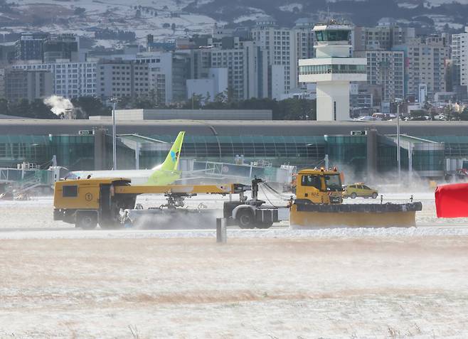 제주 전역에 많은 눈이 내린 23일 오전 제주국제공항 활주로에서 제설작업이 이뤄지고 있다.  연합뉴스