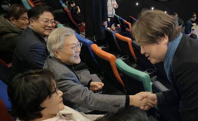 문재인 전 대통령이 22일 오후 경남 양산시내 한 영화관에서 영화 '길위에 김대중'을 관람하면서 제작진인 최낙용 시네마6411 대표와 악수하고 있다. 연합뉴스