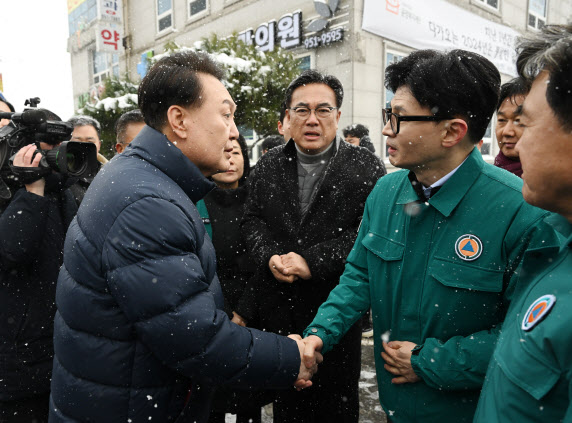 윤석열 대통령과 한동훈 국민의힘 비상대책위원장이 23일 충남 서천특화시장 화재 현장을 방문해 피해 상황을 점검한 뒤 악수하고 있다. (사진=뉴시스)