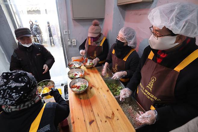 무료급식소에서 보건복지부 직원들과 급식소 봉사자들이 배식 봉사를 하고 있다. 김혜윤 기자