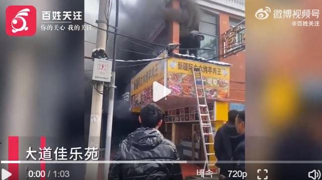 한 중국인이 24일 중국 남동부 장시성 신위시 위수이구의 한 상가 건물에서 화재가 발생하자 대피하고 있다. 웨이보 캡처