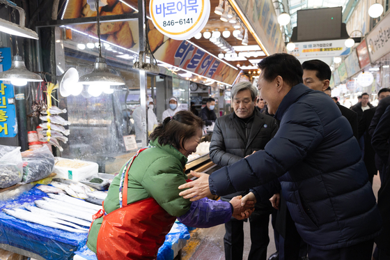 President Yoon Suk Yeol, right, meets with merchants at the Uijeongbu Jaeil Sijang in Gyeonggi on Thursday. [PRESIDENTIAL OFFICE]