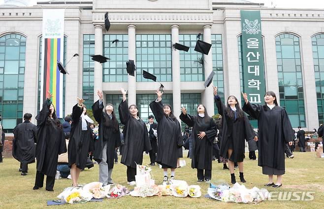 [울산=뉴시스] 배병수 기자 = 울산대학교 제50회 학위수여식이 열린 17일 오전 대학교 본관 앞 중앙공원에서 졸업생들이 학사모를 던지며 졸업을 자축하고 있다. 2023.02.17. bbs@newsis.com.