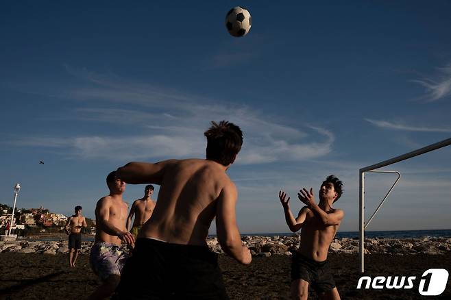 스페인 남부 도시 말라가의 12월 기온이 섭씨 29.9도를 찍으며 사상 최고 기온을 기록한 가운데 12일(현지시간) 스페인 말라가의 엘팔로 해변에서 남성들이 공놀이를 하고있다. 2023.12.12 ⓒ AFP=뉴스1 ⓒ News1 정지윤 기자