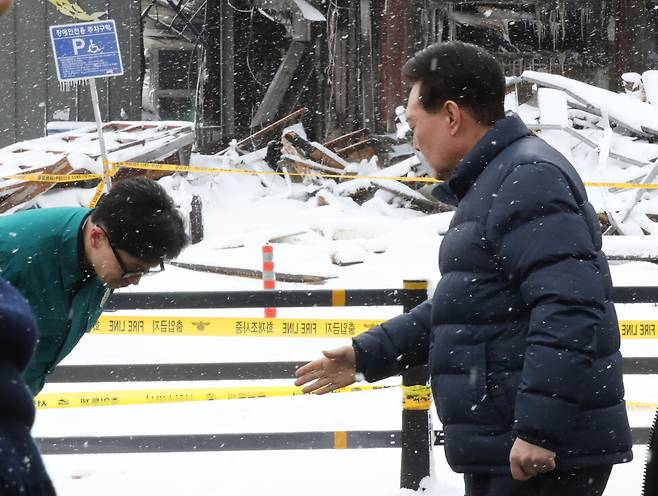 한동훈 비대위원장이 2024년 1월23일 충남 서천군 서천읍 서천특화시장 화재 현장에서 윤석열 대통령을 만나 허리 숙여 인사하고 있다. 연합뉴스