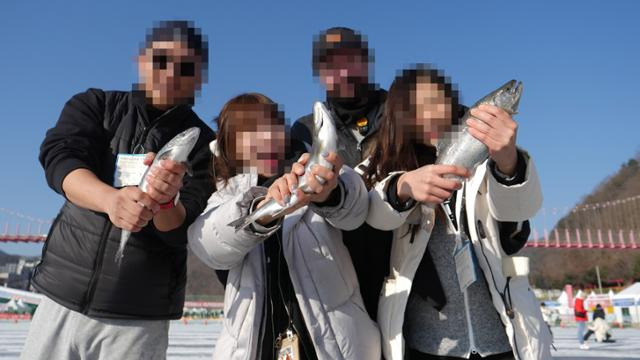 강원 화천산천어축제를 찾은 외국인 관광객들이 산천어를 낚아 올린 뒤 즐거운 표정을 짓고 있다. 화천군 제공