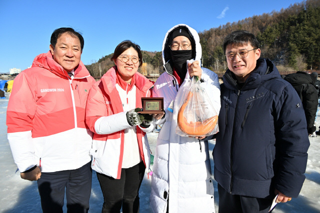 ▲ 장미란 문화체육관광부 제2 차관이 26일 평창송어축제장을 방문, 축제장과 프로그램을 돌아봤다. 얼음낚시터에서 황금송어를 잡은 관광객에게  금 반돈의 기념패를 전달하고 있다.신현태