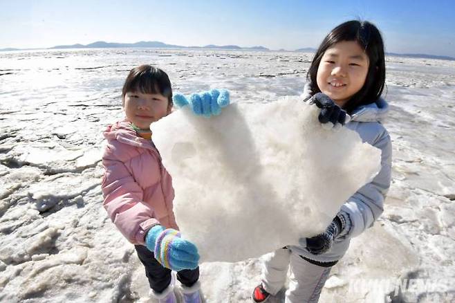 "이게 바다얼음이에요"25일 오전 인천 강화군 화도면 동막해변 앞 바닷물이 얼어붙어 있다. 북극발 한파가 만들어낸 이색 풍경이다. 강화읍에서 부모와 함께 동막해변을 찾은 자매가 바다얼음을 들어보이고 있다.