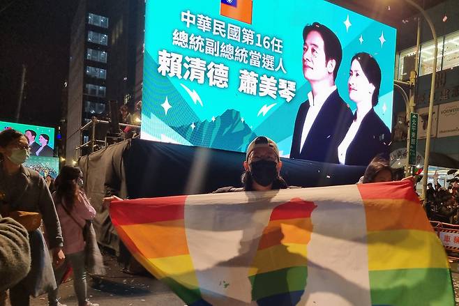 1월13일 타이페이 민진당사 앞에서 한 지지자가 타이완 독립운동과 LGBT 인권 운동을 상징하는 국기를 들고 있다. ⓒ시사IN 김영화